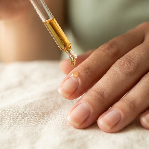 Applying botanical cuticle oil serum with glass dropper